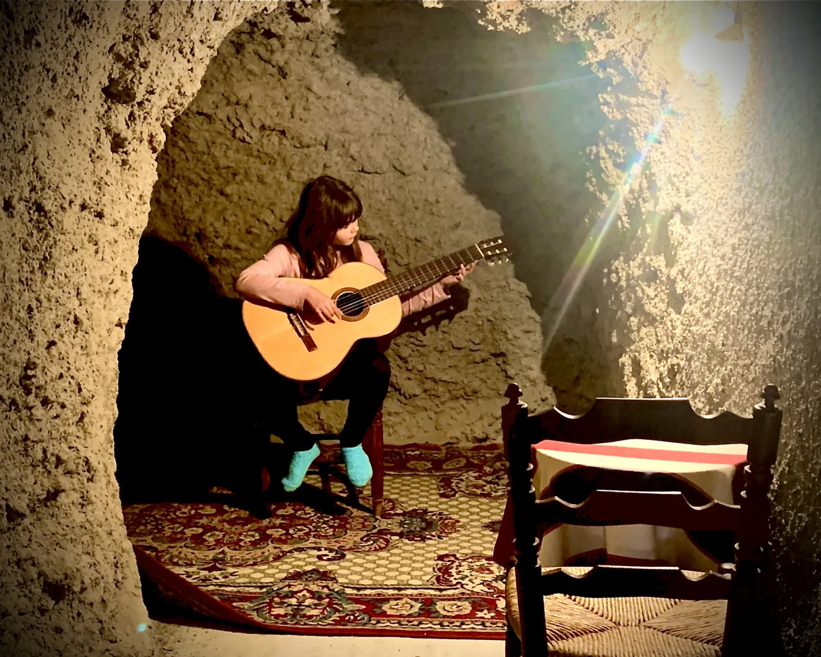 Persona tocando la guitarra en la habitación cueva