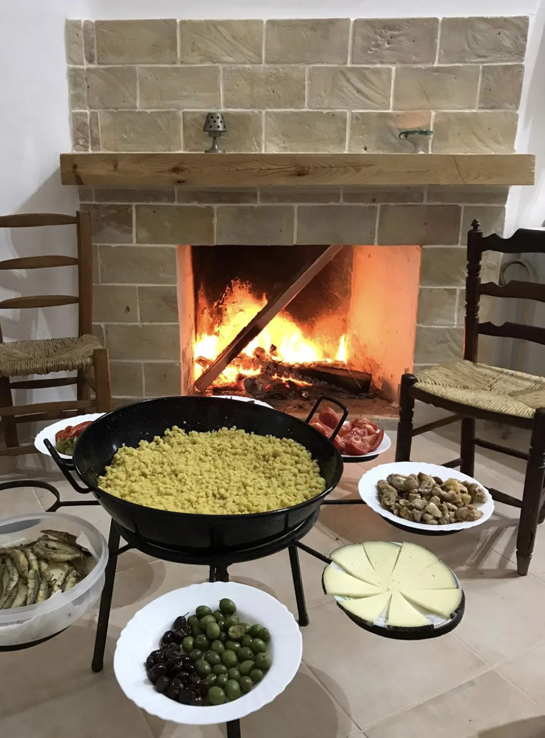 Chimenea encendida con una paella cocinándose